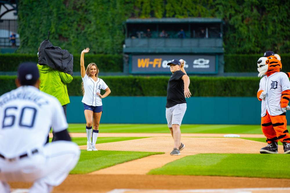 Individual throwing a pitch to a Tigers player